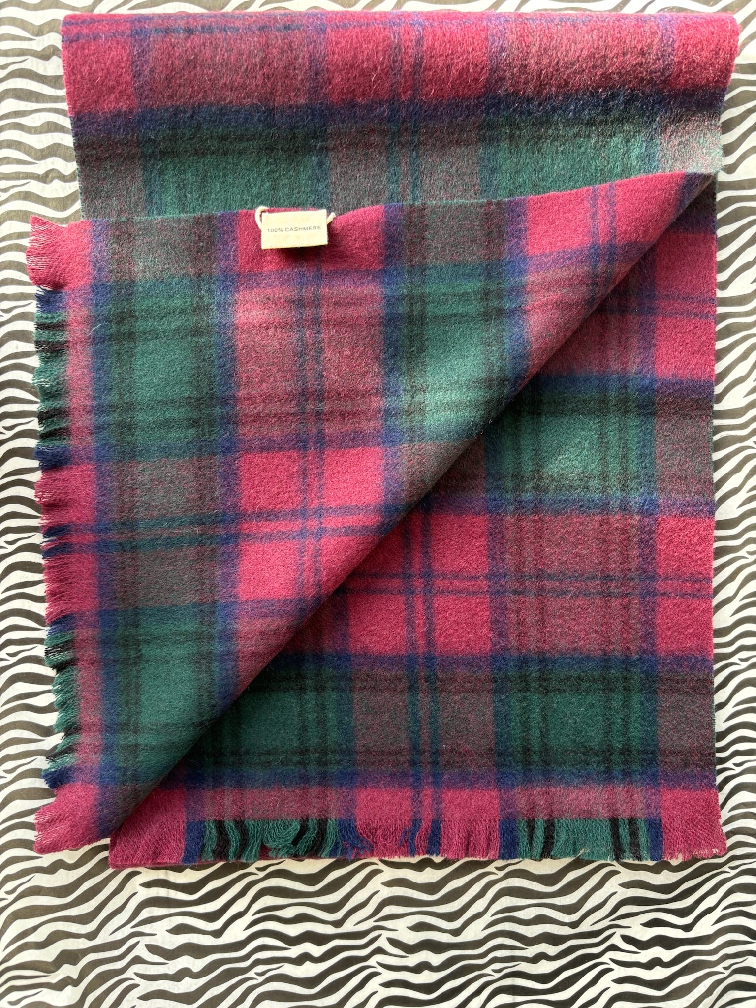 Woman wearing a plaid scarf in a clothing store