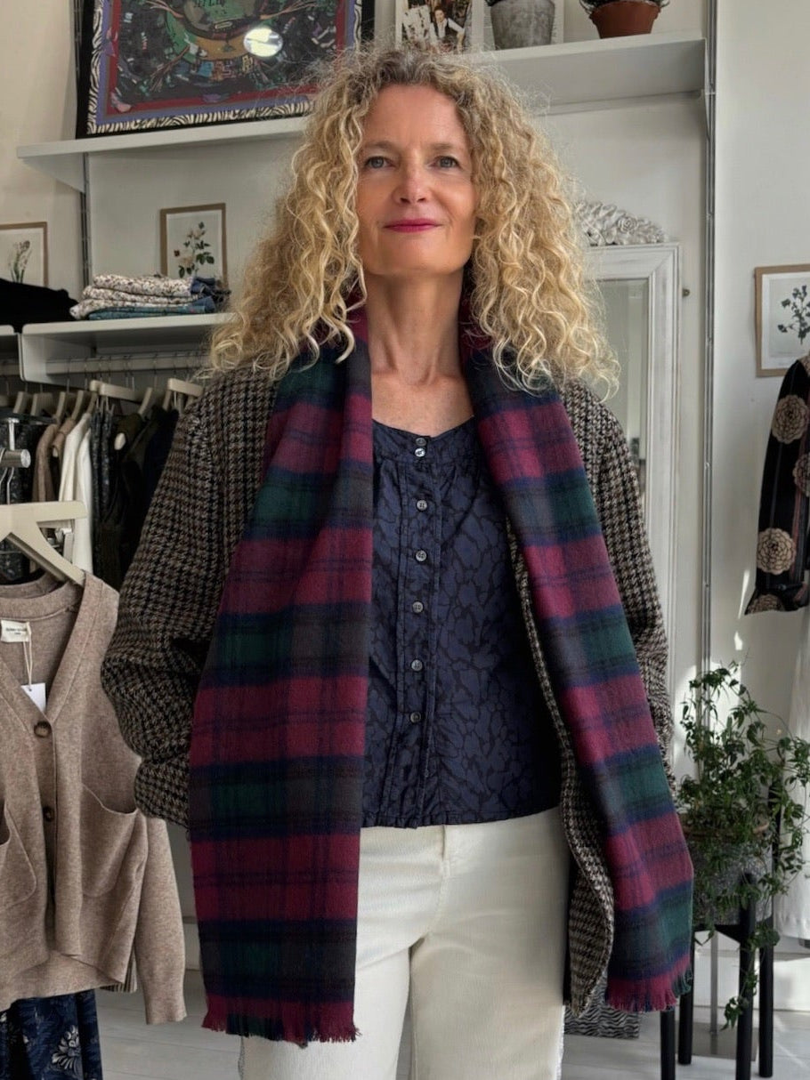 Woman wearing a plaid scarf in a clothing store